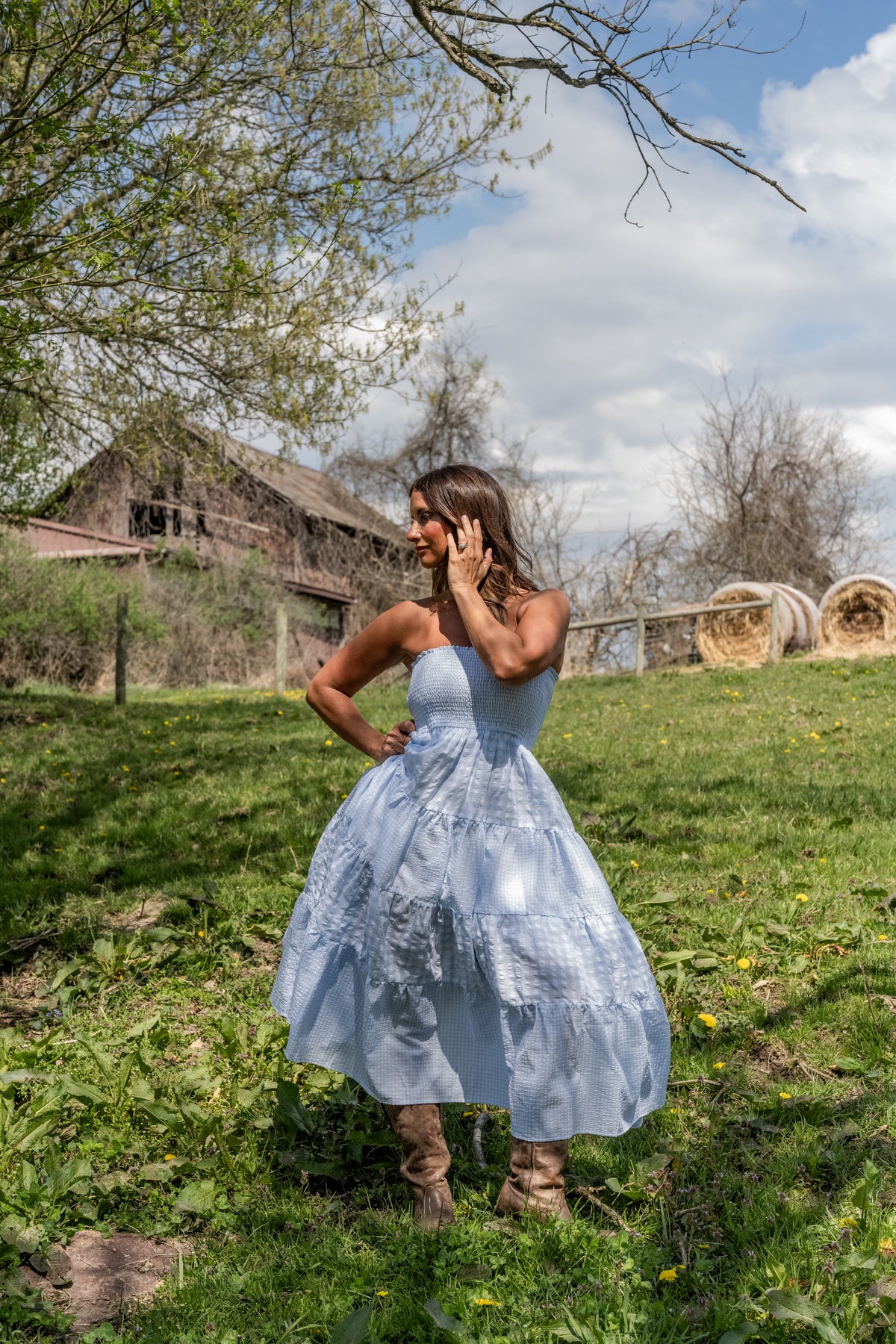 Woman wearing blue dress standing outdoors in field